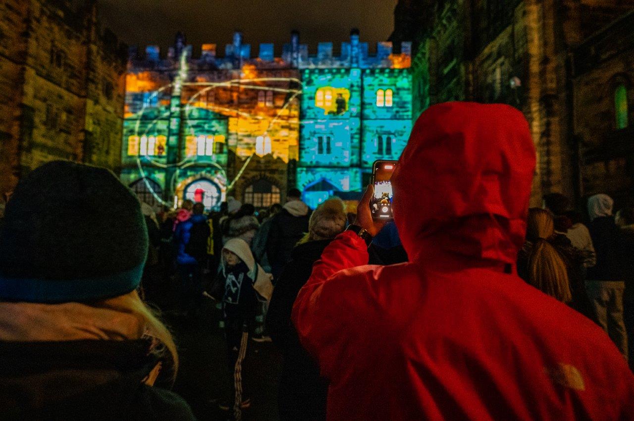 Crowd enjoying the spectacular light display projected on to Lancaster Castle